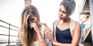 sad woman comforted by friend