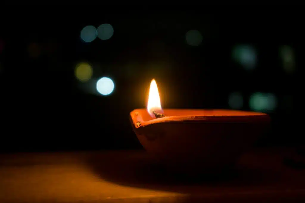 a lit candle sitting on top of a wooden table