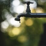 tilt shift lens photography of black steel faucet