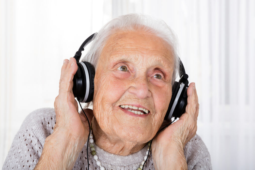 old woman with headphones listening to music